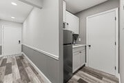 View of the front door leading to the kitchenette and full bathroom.